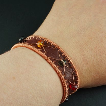 Copper cuff bracelet with leather and glass beads.
